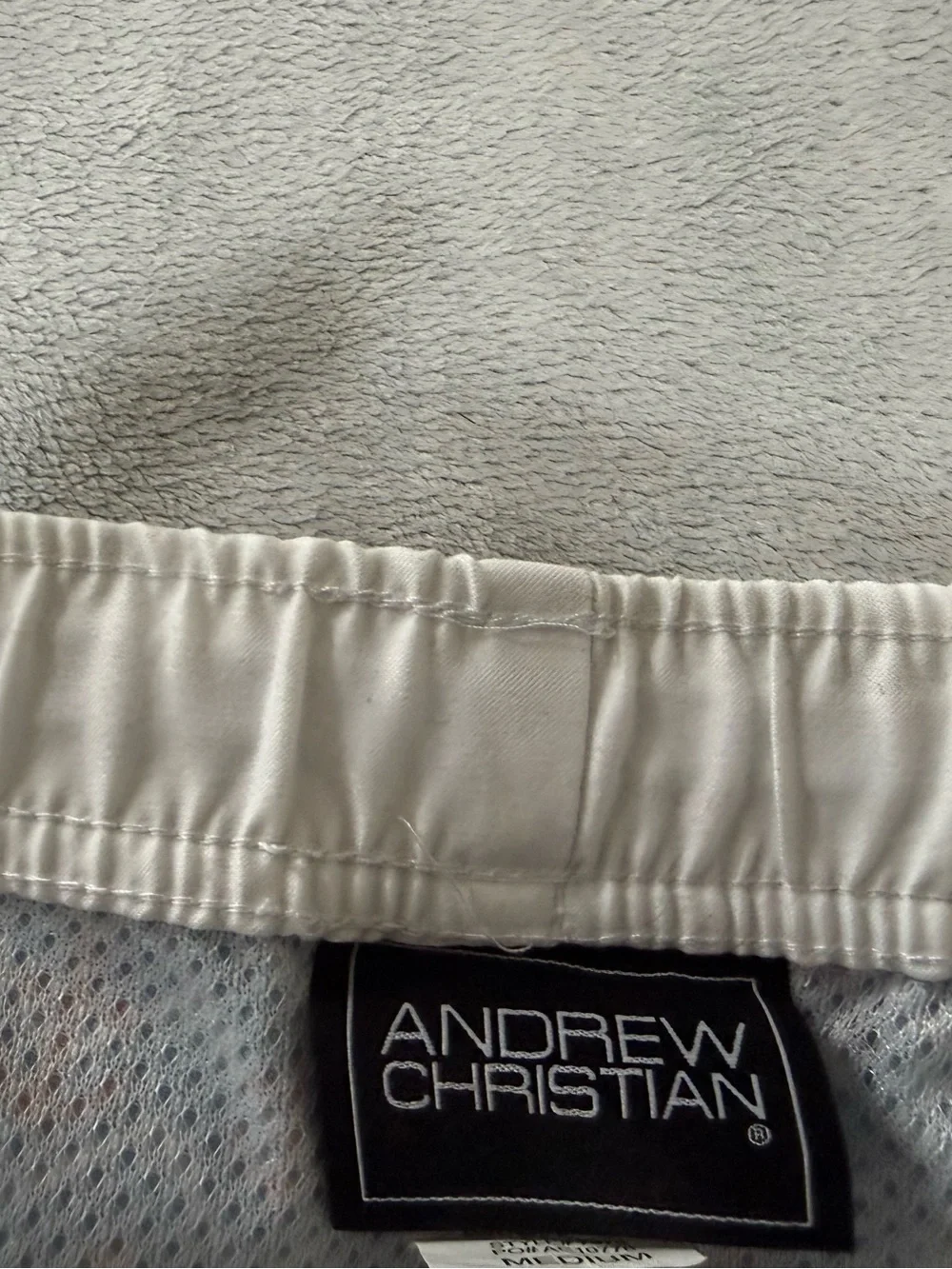 Andrew Christian blue, red and white lined swim trunks. Men’s size medium.